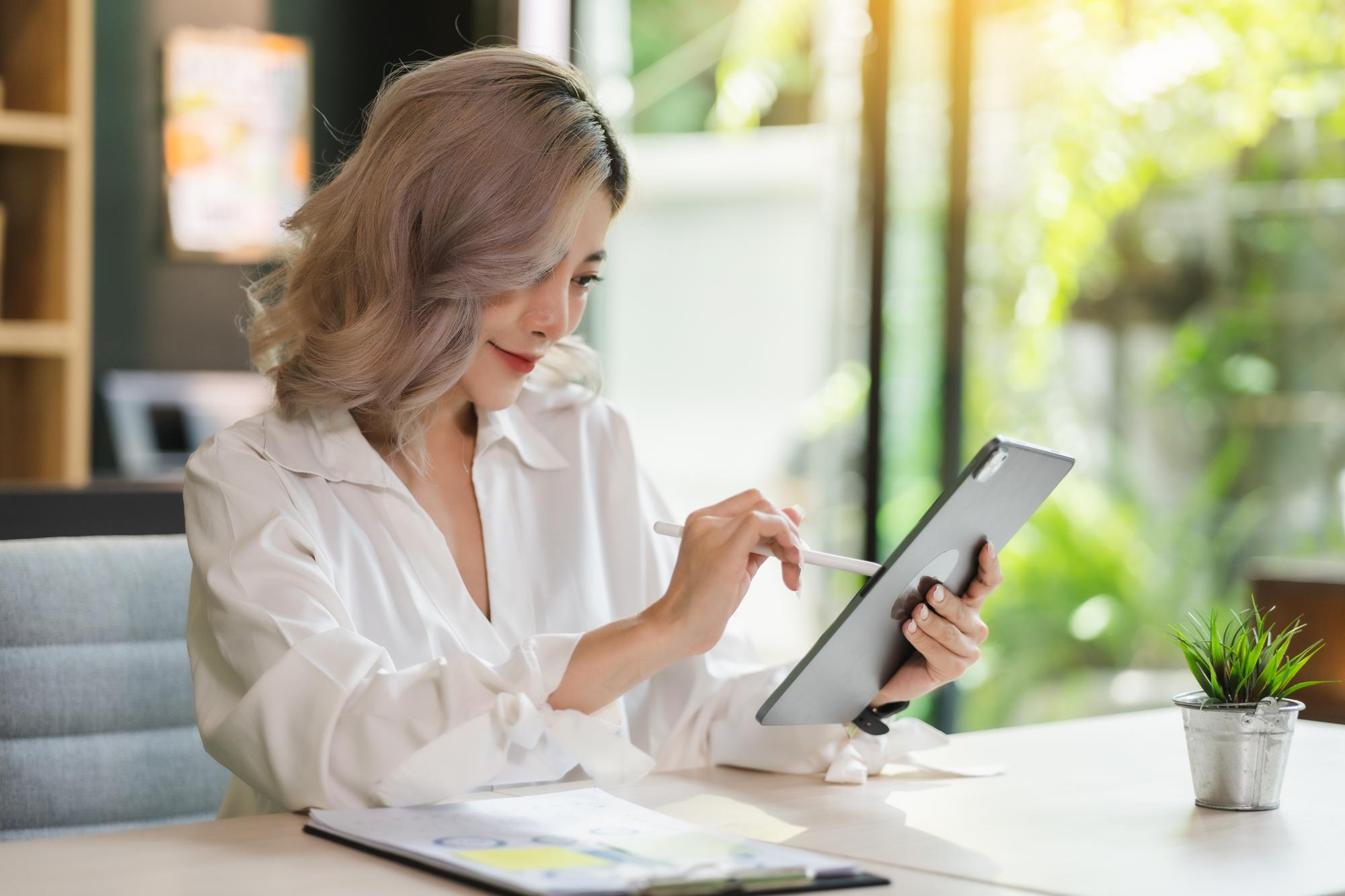 Beraterin erläutert Finanzplan an Tablet